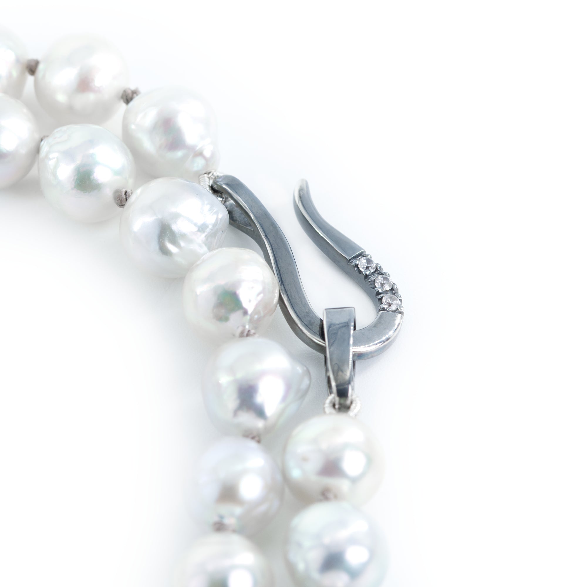 The photo shows a piece of a gray pearl necklace showing the clasp details.