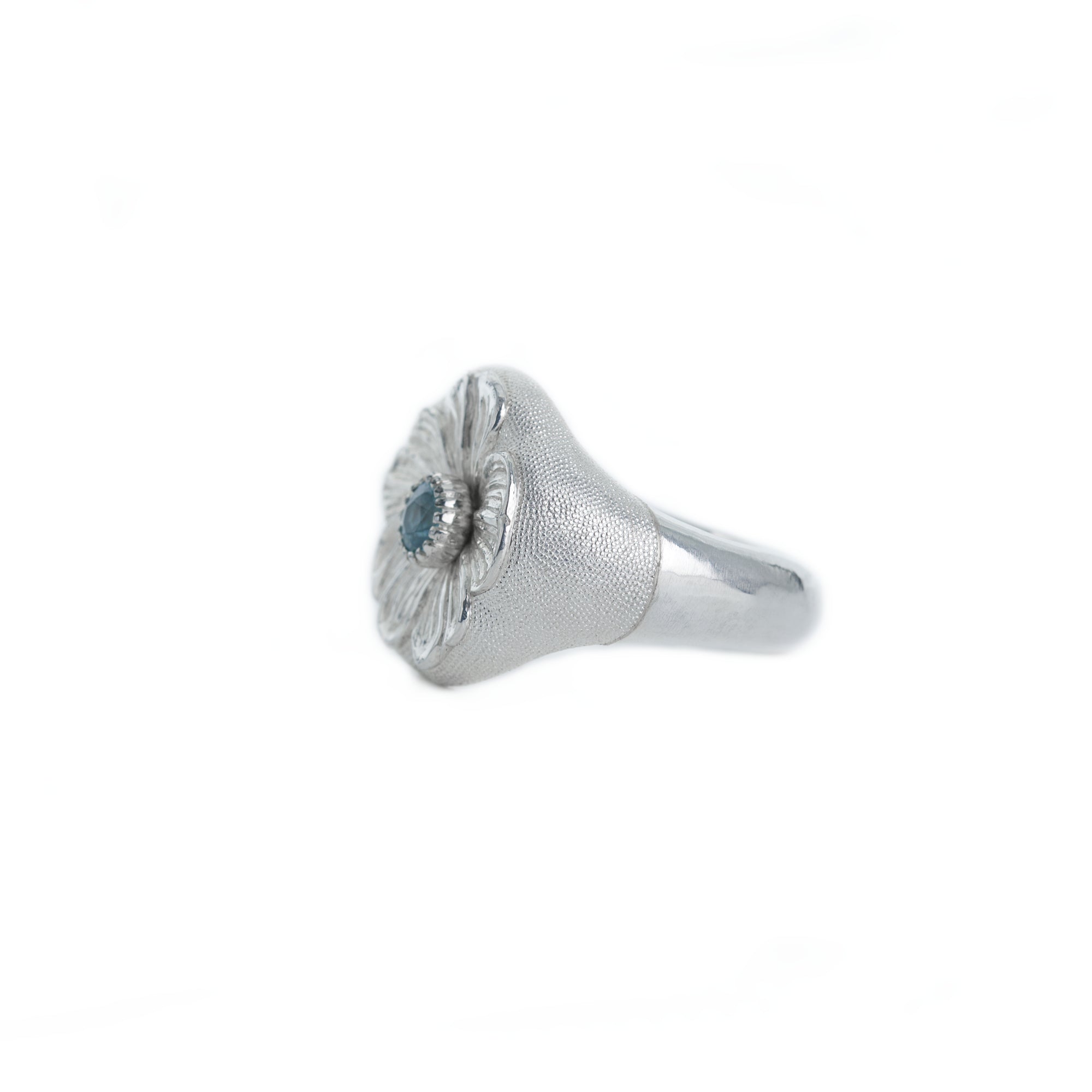 Silver ring with a blue gemstone on a white background