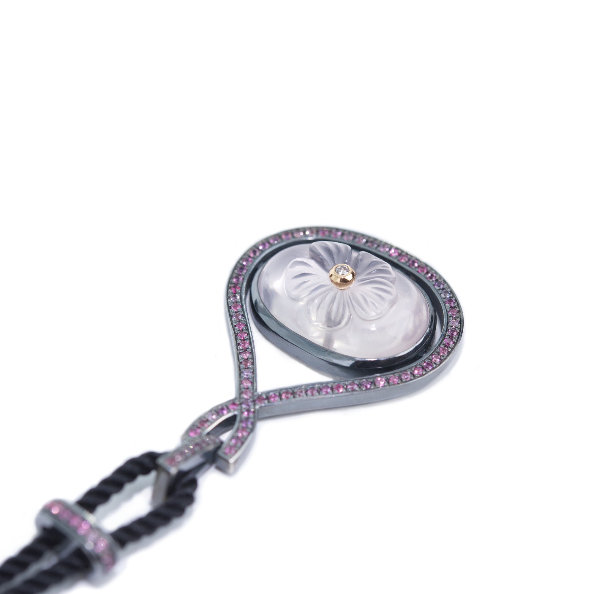 Photo presents a detail of the necklace: the flower carved in rose quartz. The pendant is on white background.