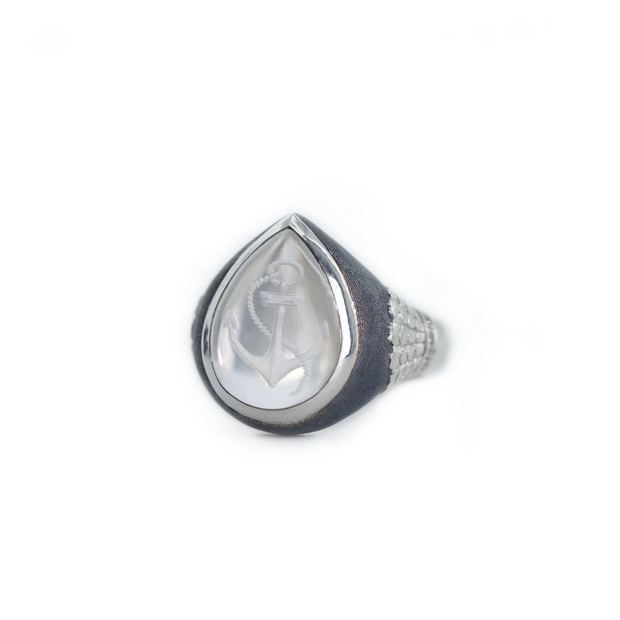 Teardrop-shaped silver ring with a clear stone on a white background