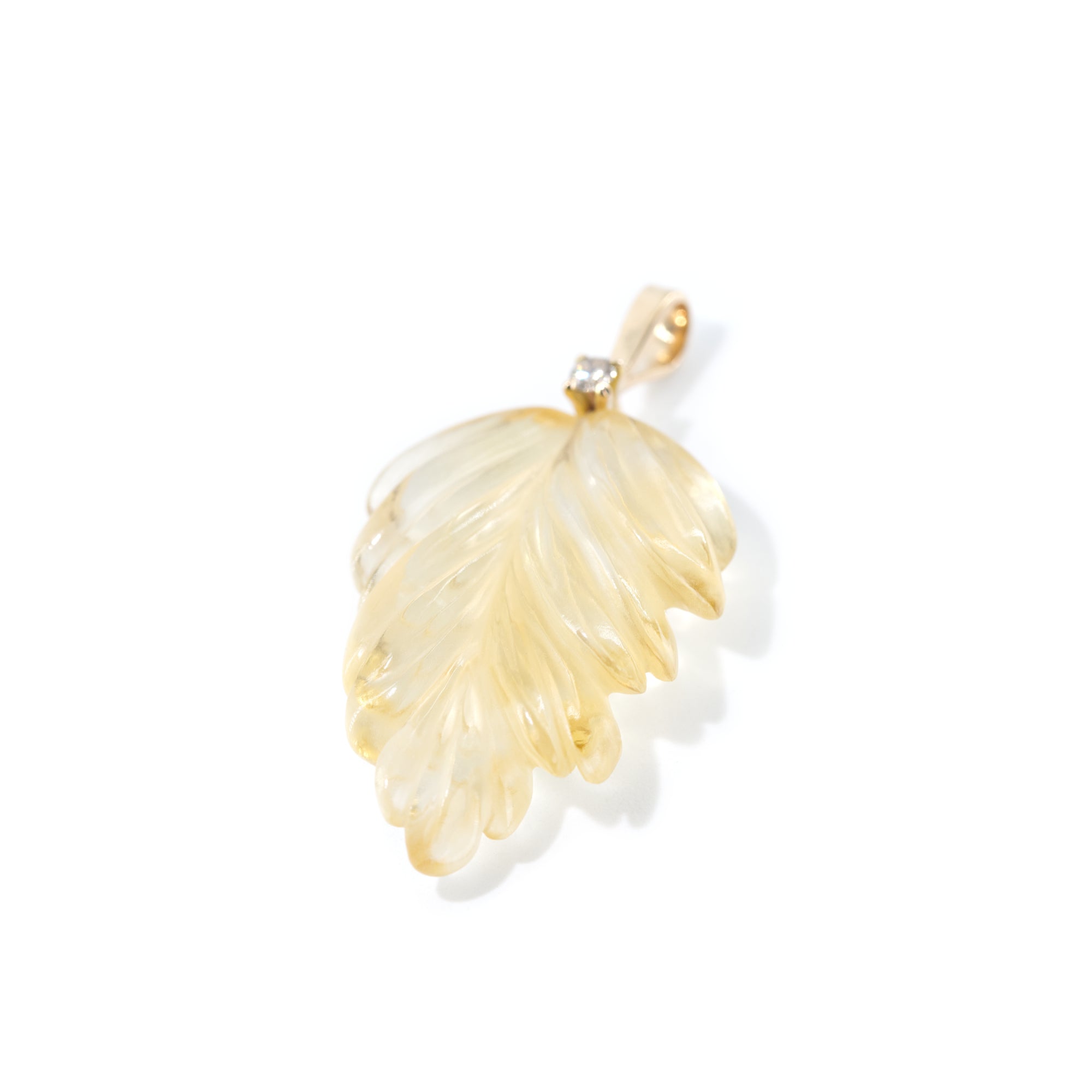 The photo features hand-carved citrine leaf pendant. The pendant is placed vertically to highlight the detailed work of hand-carving.