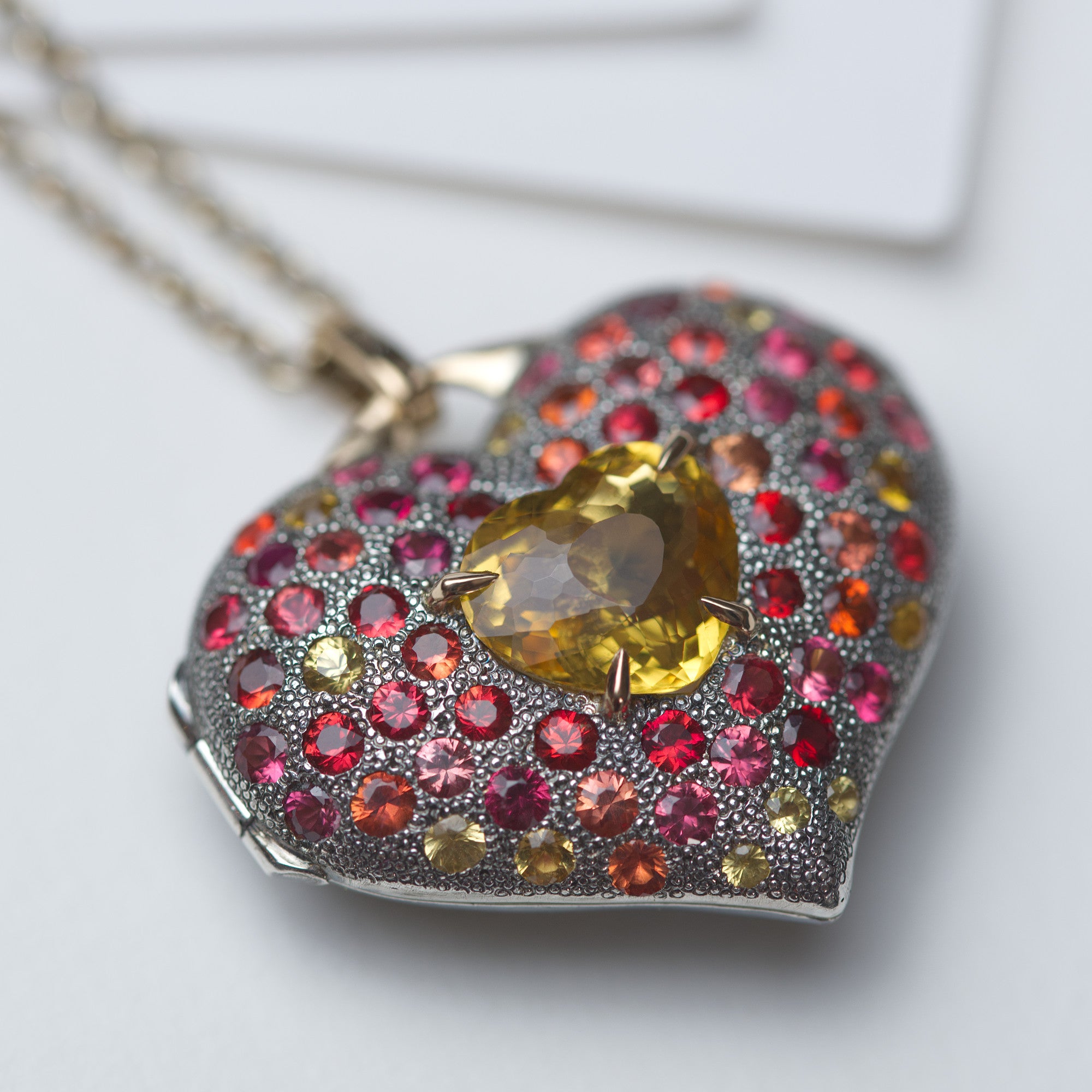 Heart locket in 18K gold, sterling silver with fancy sapphires and heliodor