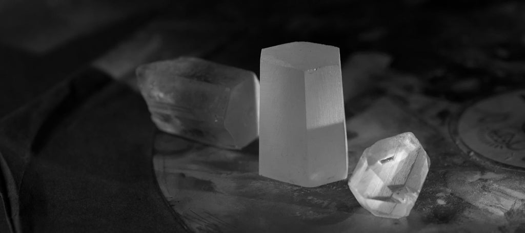 One crystal cut into three, one part already shaped.