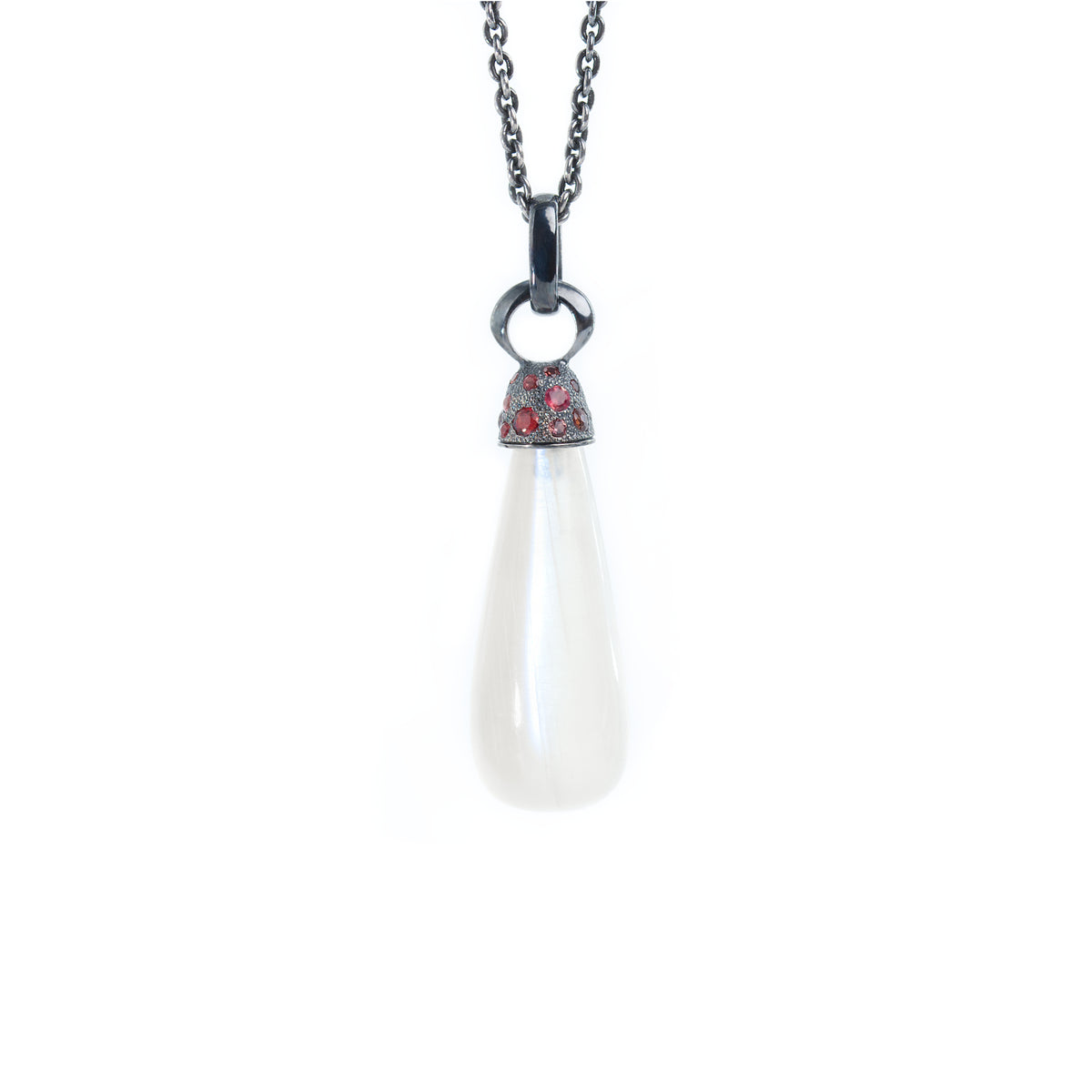 Moonstone necklace adorned with blackened silver cap with  red sapphires hanging from simple chain. Necklace showed on white background.