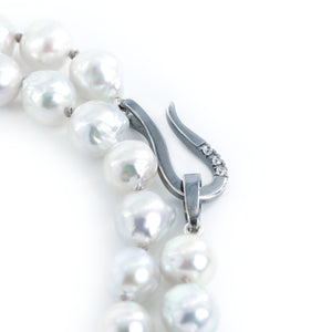 The photo shows a piece of a gray pearl necklace showing the clasp details.