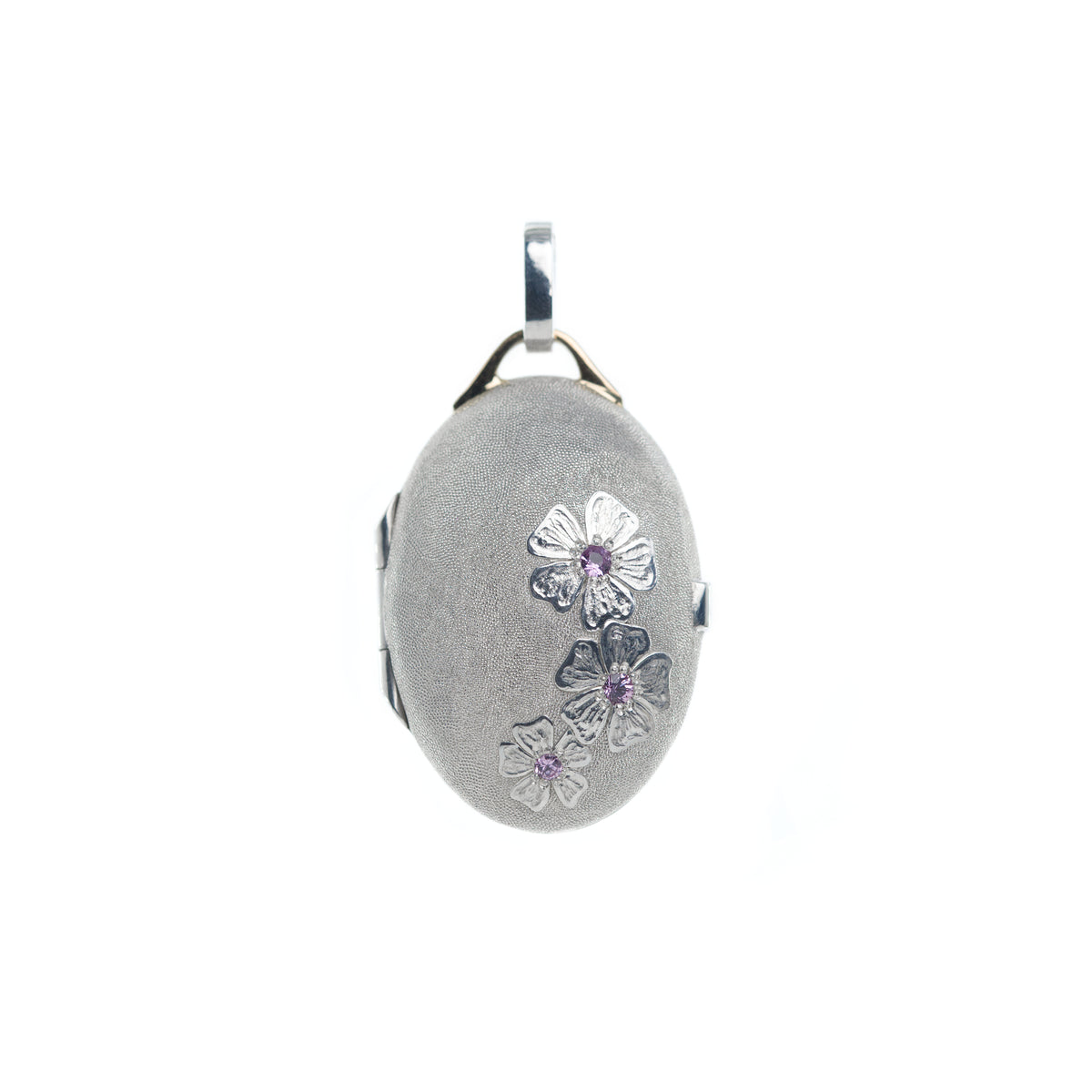 Bright silver locket with 18K gold details and hand engraved cherry blossom flowers adorned with pink sapphires is presented on the white background. Locket by Ewa Z. Sleziona Jewellery