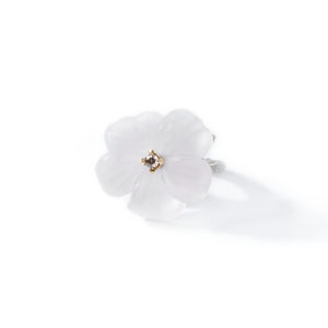 White pansy flower ring carved in rock crystal and adorned with chocolate diamond presented on white background.