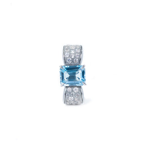 The photo shows the front view of the bow-shaped ring. In the center of the bow there is an octagonal blue topaz, the sides of the bow are decorated with round white zircons. The design of the ring is in the classic Art Deco style.