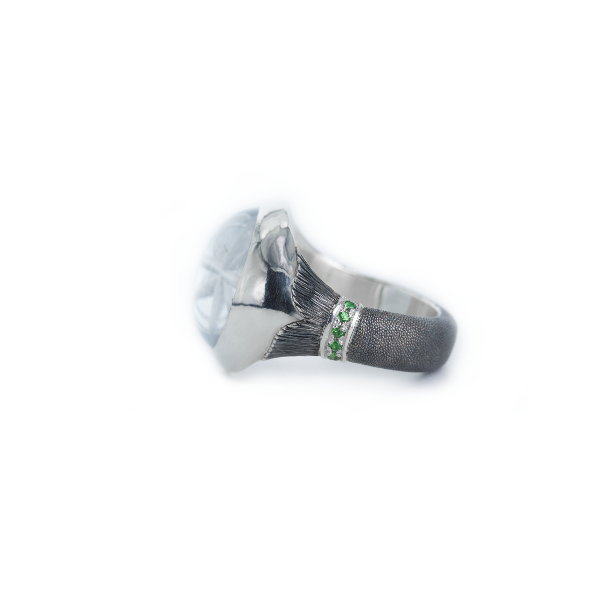 Silver ring with green gemstone on a white background