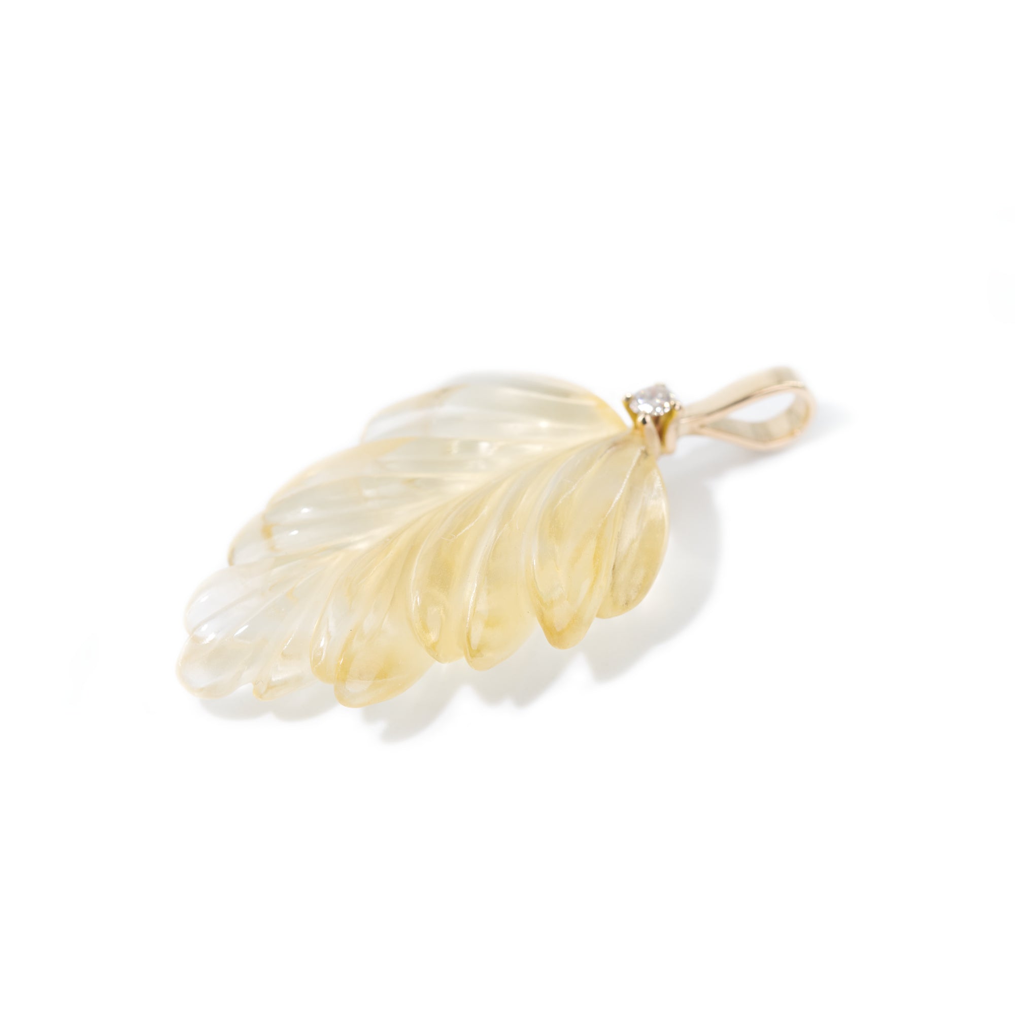 The photo features hand-carved citrine leaf pendant. The pendant is placed on the side to present the detailed work of hand-carving.