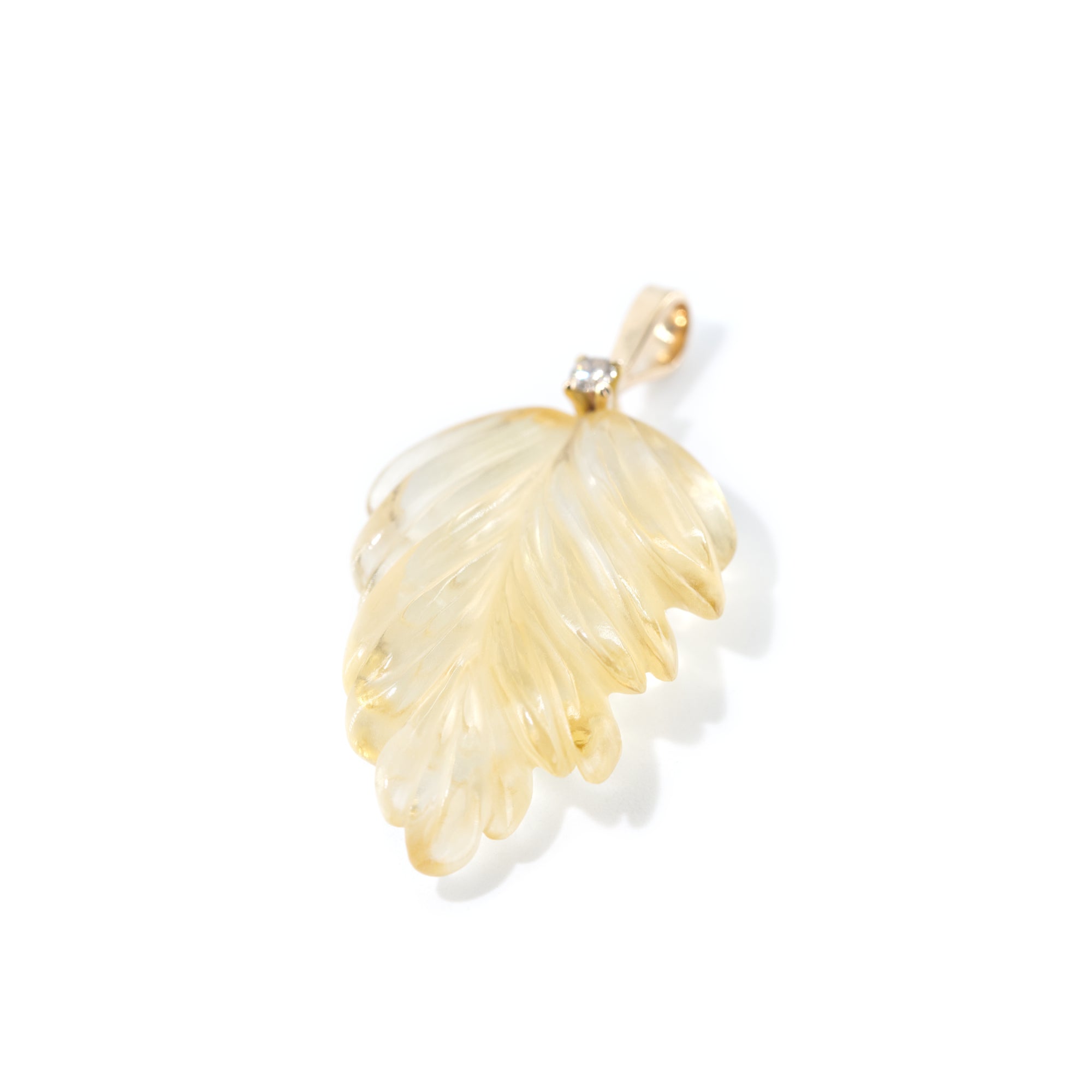 The photo features hand-carved citrine leaf pendant. The pendant is placed vertically  to highlight the detailed work of hand-carving.