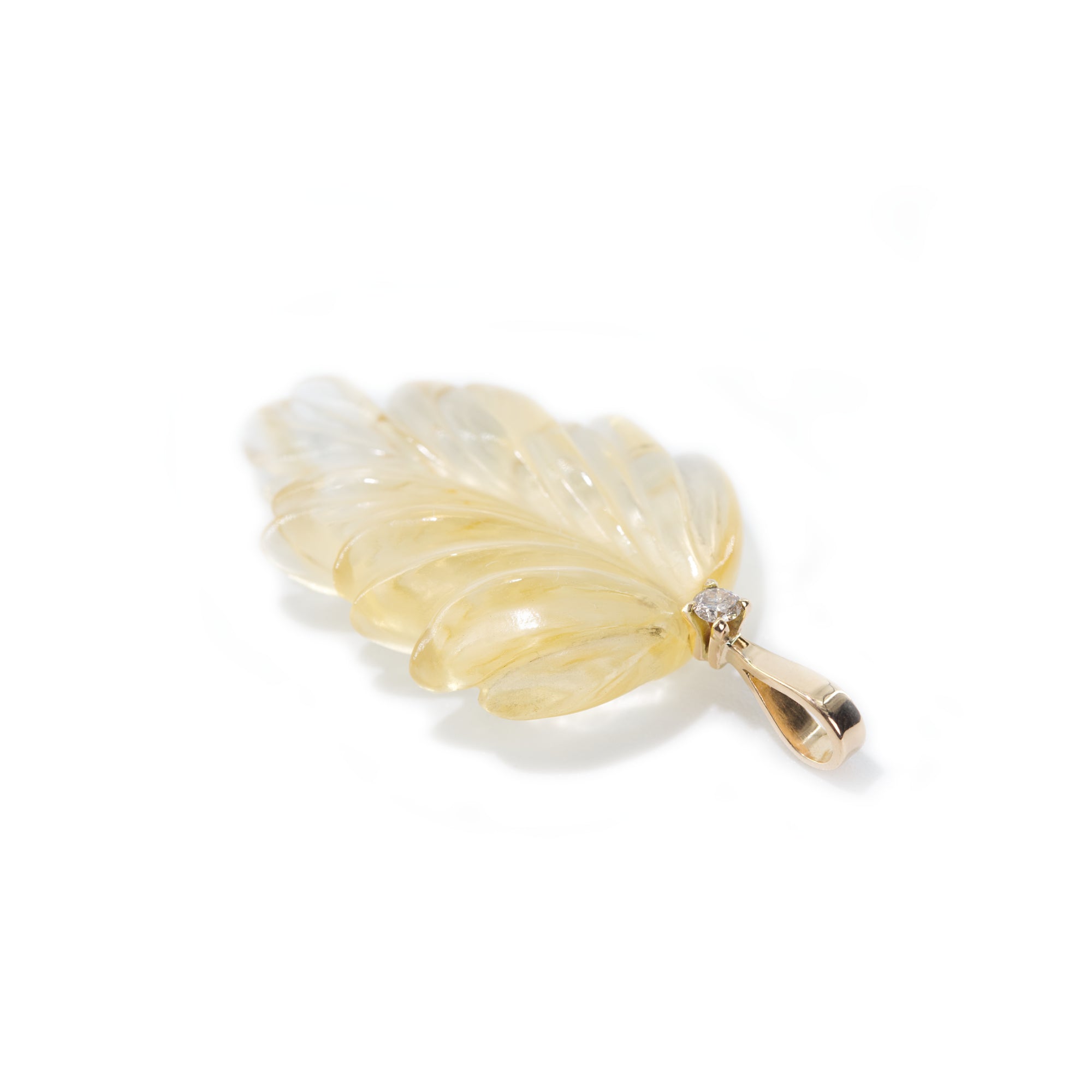 The photo features hand-carved citrine leaf pendant. The pendant is placed on the side to present the bail of the pendant which is made of 18K gold and finished with light brown diamond.