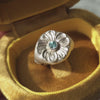 A short video presenting flower signet ring with blue gemstone in golden jewellery box.
